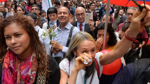 Colombians celebrate in downtown Bogota as they watch on a giant screen the signing of the ceasefire in Havana