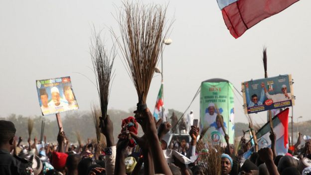 Supporters of Muhammadu Buhari holding up brooms at a rally in Nigeria - 2015