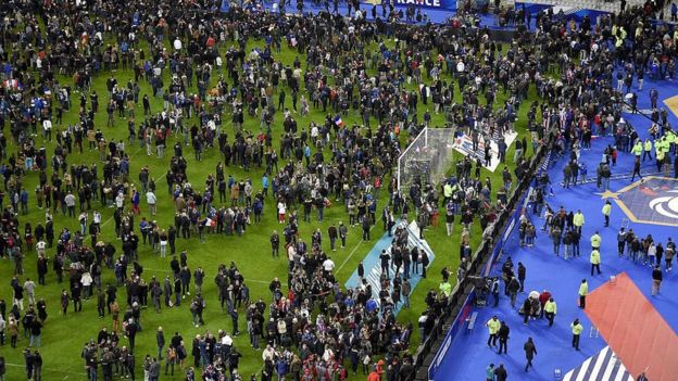 Football fans gather on the field of the Stade de France stadium after explosions during a friendly football match between France and Germany in Saint-Denis, north of Paris, on 13 November 2015 - one of a number of deadly attacks on the night