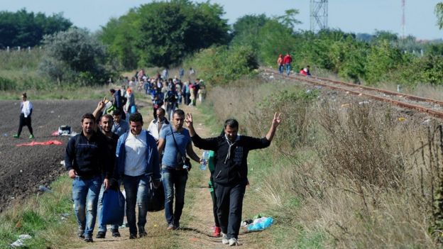 Migrants walk alongside a railway in Hungary