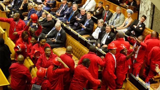 Members of the Economic Freedom Fighters political party leave the inside of parliament as during President Jacob Zuma's State of the Nation address in Cape Town on February 11, 2016.
