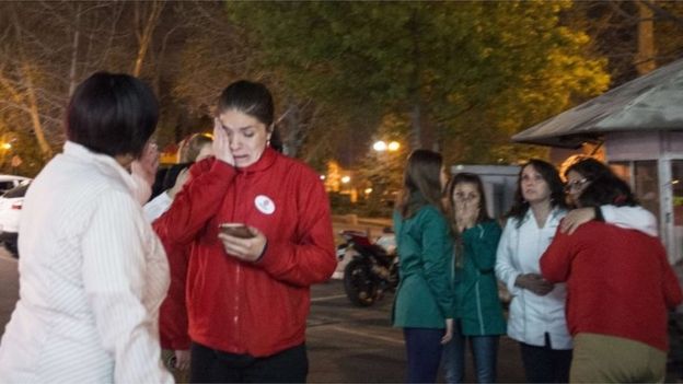 Women remain at a street during a strong quake in Santiago on 16 September, 2015.