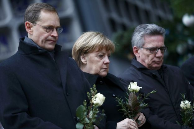 Berlin Mayor Michael Mueller (L), German Chancellor Angela Merkel and German interior minister Thomas de Maiziere stand in silence at the Christmas market in Berlin, Germany, 20 December