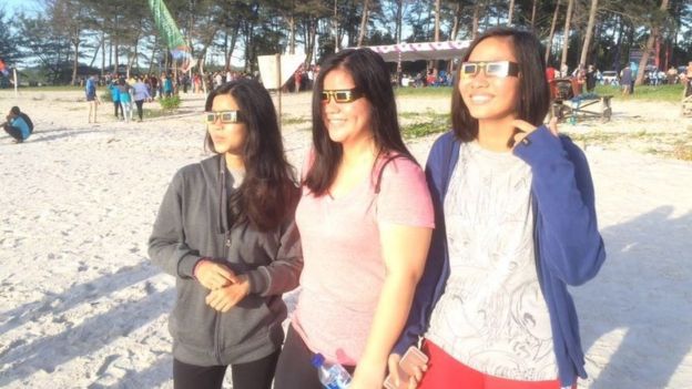 People watch the solar eclipse on Olivier beach, Belitung