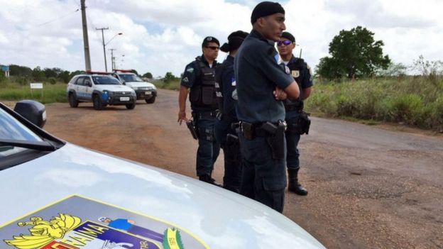Police stand outside the prison, in the outskirts of the state capital, Boa Vista