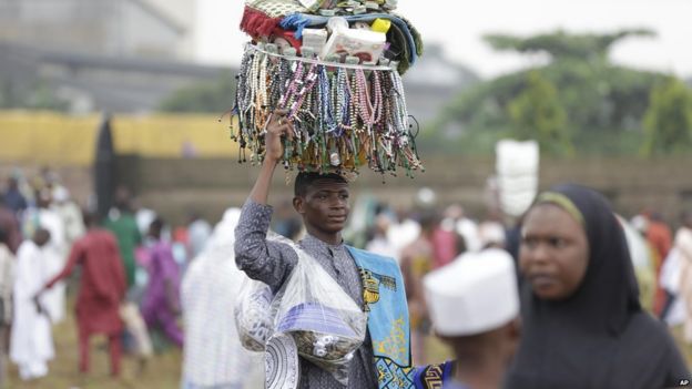 A man sells prayer beads and prayer caps during Eid al-Fitr in Lagos, Nigeria, Friday, July 17, 2015