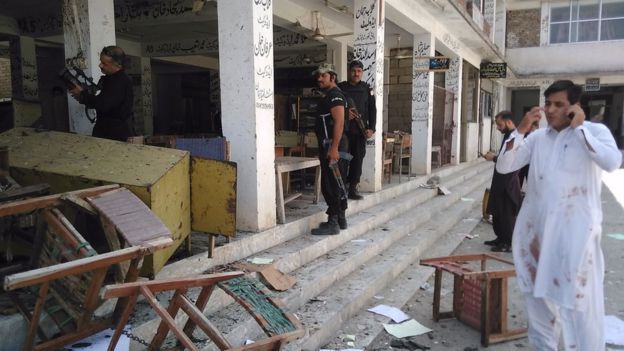Pakistani police officials inspect the site of a suicide bomb attack at a district court in Mardan on September 2, 2016