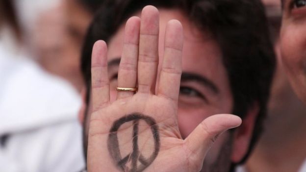 A man shows the palm of his hand with a peace sign drawn on it at the Bolivar square outside the cathedral in Bogota, Colombia, September 26, 2016