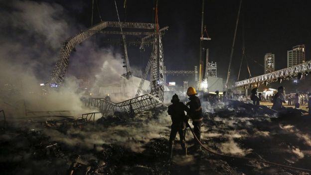 Firefighters try to extinguish a fire at the venue of a cultural event during 