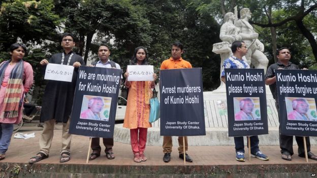 Bangladeshis stand with placards that read 