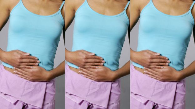 Mulher segura a barriga com dor de cólica menstrual