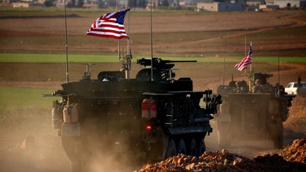 A convoy of US forces armoured vehicles drives near the village of Yalanli, on the western outskirts of the northern Syrian city of Manbij (5 March 2017)