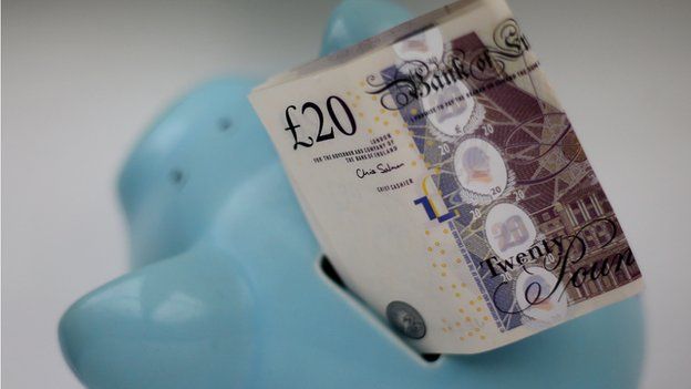 Twenty pound notes in a piggy bank