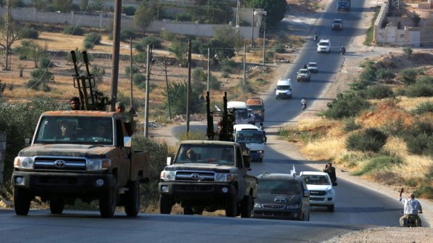 A convoy of vehicles arrives in rebel-held Idlib, Syria