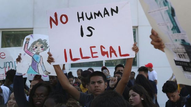 Un joven sostiene un cartel con la leyenda 