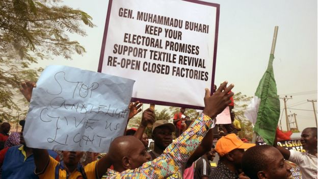 People holding placards in a February demonstration asking President Buhari to keep electoral promises of a textile revival by re-opening closed factories.