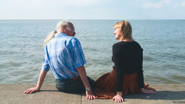 Couple talking, sitting by the seaside