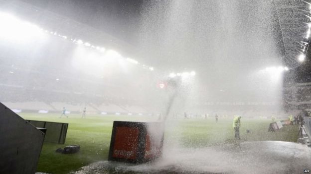 A football game in France is interrupted by heavy rain