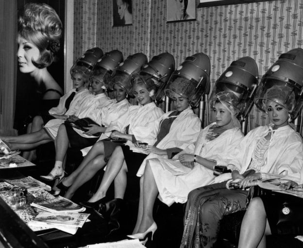 A group of Miss World contestants line up under the hairdryers at La Belle hairdressing salon in Aldwych, London