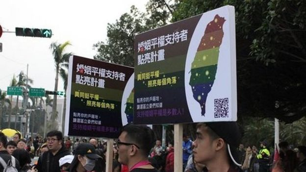 許多志工在現場舉著告示牌，期盼婚姻平權可以藉由民法修正趕快通過。