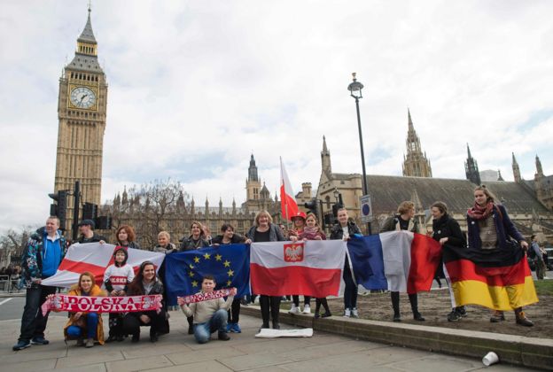 Protestors pose for a photograph with flags from England, European Union, Poland, France and Germany in front of the Elizabeth Tower, better known as