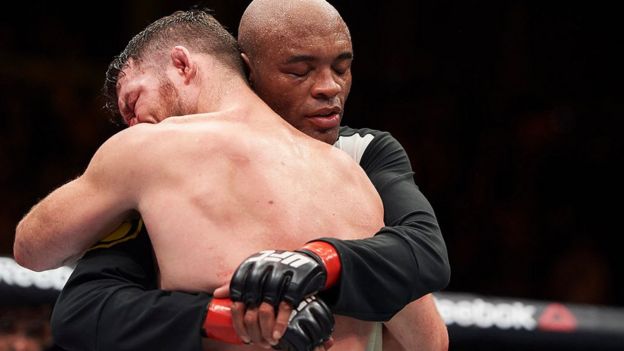Boxeadores Michael Bisping y Anderson Silva abrazándose