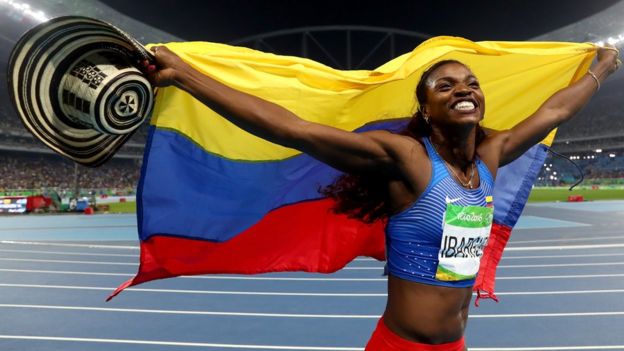 Caterine Ibargüen festeja con la bandera de Colombia