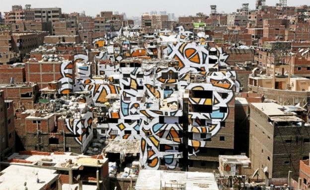 A mural painted on the walls of houses in Zaraeeb, created by French-Tunisian artist El Seed, is pictured in the shanty area known also as Zabaleen or 