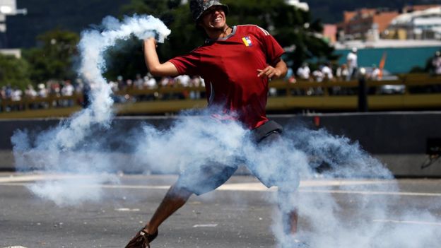 Un manifestante con una bomba de humo
