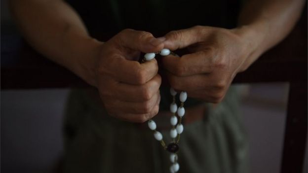 This photo taken on May 24, 2015 shows a worshipper holds rosary beads after a service celebrating the Feast of the Ascension at the 