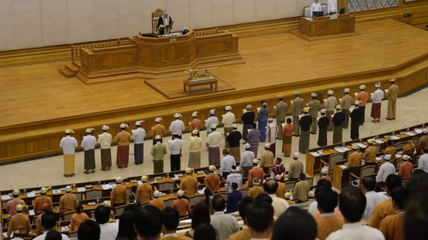 New Myanmar Ministers including the country's democracy icon Aung San Suu Kyi (front row 9th R, in blue) are sworn into office by Upper House Speaker Mahn Win Khine (on podium) during a ceremony at the parliament in Naypyidaw on March 30, 2016