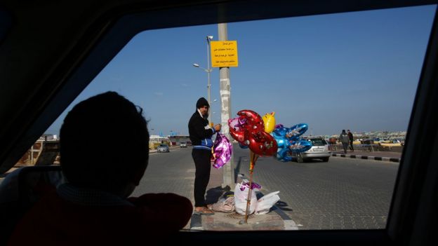 Palestinian street vendor standing at the port in Gaza City