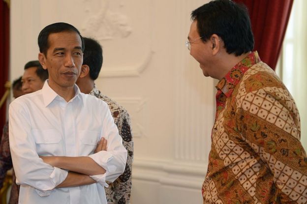 Indonesian President Joko Widodo (L) listens to acting Jakarta Governor Basuki Tjahaja Purnama alias Ahok (R) at the presidential palace in Jakarta on October 22, 2014.