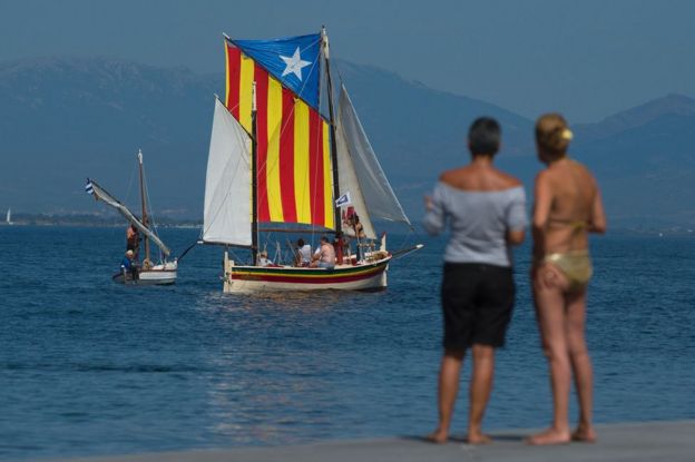 A sail boat carrying an Estelada Catalan independence flag sails off a beach near Girona, 10 September
