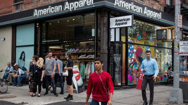 People walk past an American Apparel store on June 19, 2014 in New York City.