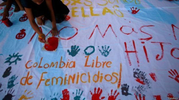 Una mujer pinta un cartel para protestar contra los feminicidios.