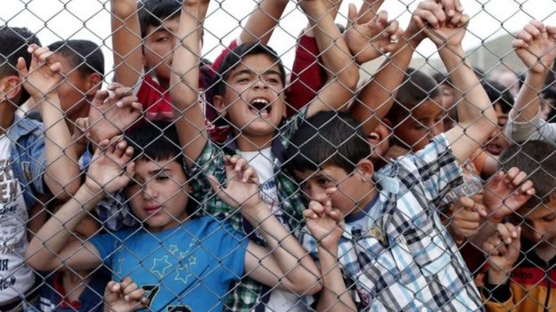 Syrian refugee children stand behind a fence at the Nizip migrant camp in Turkey. Photo: April 2016