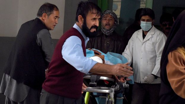 Afghan relatives and doctors move a wounded Afghan man at the Estiqlal Hospital after a massive suicide blast at a Shia mosque in Kabul on 21 November 2016