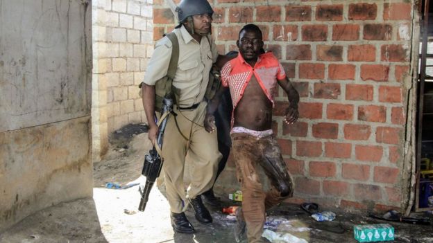 A Zambian policeman arresting a rioter in Lusaka - April 2016