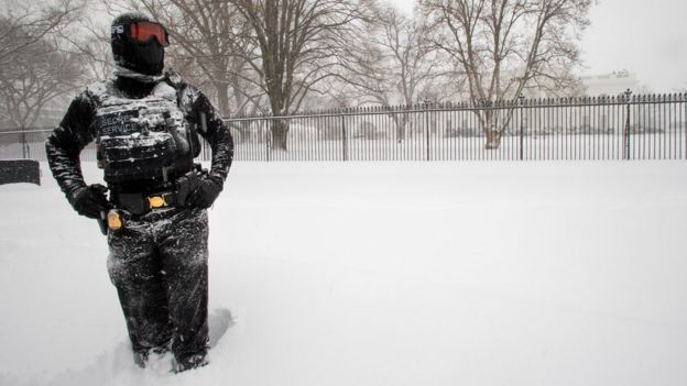 A uniformed U.S. Secret Service police officer stands guard in a knee-deep snow outside the White House in Washington, Saturday, Jan. 23, 2016