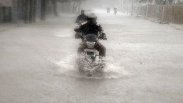 A man rides his motorbike through a flooded road during heavy rain in Chennai, India, November 9, 2015.