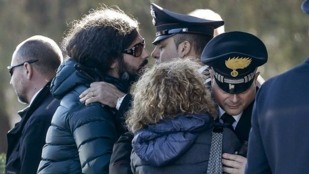 Giovanna Di Agostino, mother of Italian victim Fabrizia Di Lorenzo, and her son Gerardo, left, are hugged by authorities upon their arrival from Berlin with the coffin of her daughter Italian victim Fabrizia Di Lorenzo, at Rome