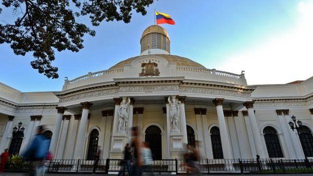 People walk past the National Assembly building in Caracas, on 7 December, 2015