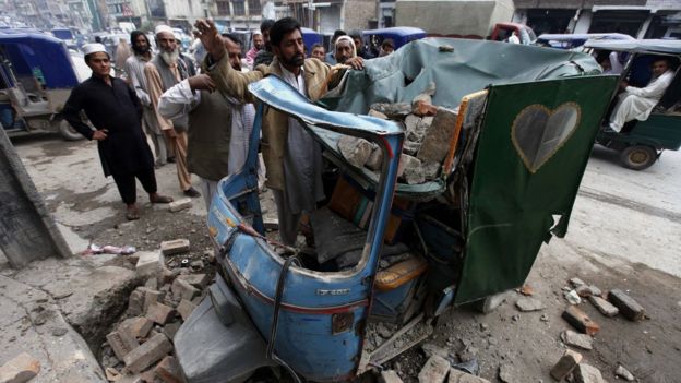 People remove debris from a rickshaw in Peshawar, Pakistan. 26 Oct 2015
