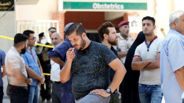 Relatives of babies killed in a fire at the Yarmouk Hospital in Baghdad wait outside the maternity unit (10 August 2016)