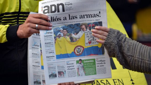 Colombians read newspapers with headlines about the ceasefire agreement between the government and the Farc in Bogota on June 23