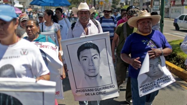 A relative (C) of Mexican missing student Jhosivani Guerrero de la Cruz holds his portrait during a march in Acapulco, Guerrero State, Mexico, on March 4, 2015. Jhosivani Guerrero is the second of the 43 missing students of Ayotzinapa whose remains are identified, the Mexican government informed on September 16, 2015. AFP