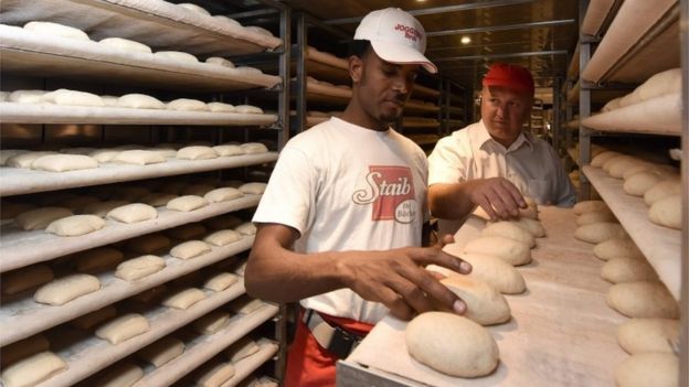 Baker in training Ghebru Aregay [L) works togther with Baker teacher Marcus Staib (R) at a bakery in Ulm, Germany, 16 September 2015. The refugee from Eritrea began training to be a baker.