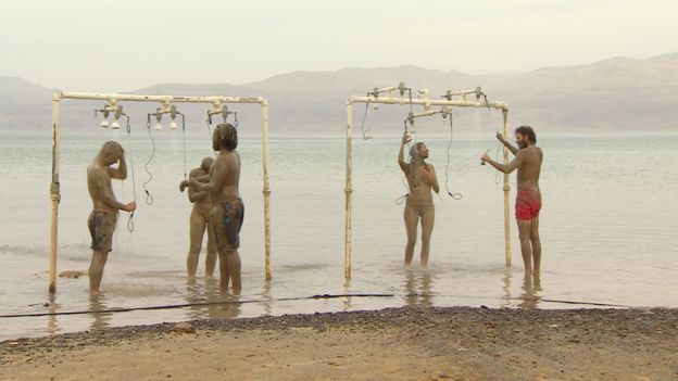 Visitantes se quitan el agua y barro del Mar Muerto en estas duchas públicas