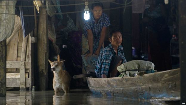 Residents look out from a monastery submerged by floodwaters in Kyouk Ye village near Hinthada town in Irrawaddy region on 6 August 2015